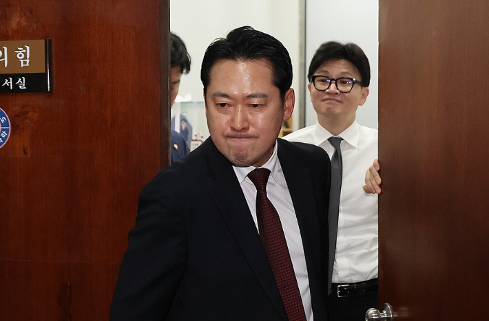 지난해 12월 11일 당시 국민의힘 장동혁 의원이 국민의힘 당대표실을 나가는 사이 한동훈 국민의힘 전 대표가 미소를 짓고 있다. 연합뉴스