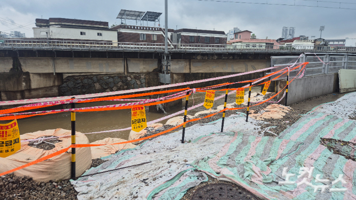 지난 7월 17일 집중호우로 인한 빗물 압력을 견디지 못한 광주 북구 신안교 인근 투명 홍수방어벽 일부가 무너져 내린 모습. 한아름 기자