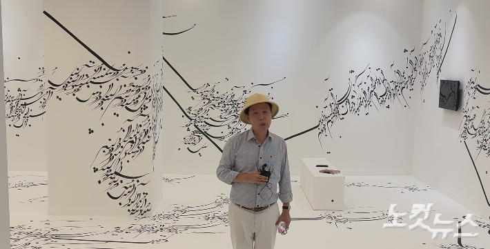 27일 전남 목포시 목포 문화예술회관에서 열린 2025 전남 국제 수묵 비엔날레 프레스 오픈에서 윤재갑 총감독이 이란 출신 작가 파라스투 포로우하르의 작품 'Written Room'을 설명하고 있다. 김한영 기자 