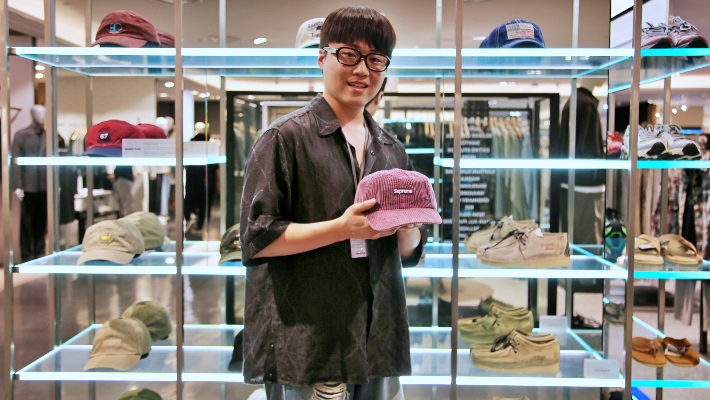 광주신세계 본관 7층 '시리즈' 매장에 마련된 편집샵에서 직원이 '슈프림'의 모자를 선보이고 있다. 광주신세계 제공