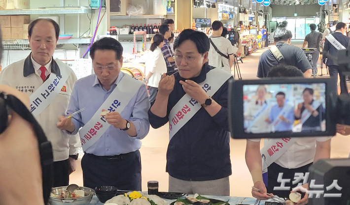 유정복(가운데) 인천시장과 박용철(오른쪽) 강화군수 등이 인천 강화군 외포항 수산물 직판장에서 각종 수산물에 대한 시식을 하고 있는 모습. 박창주 기자