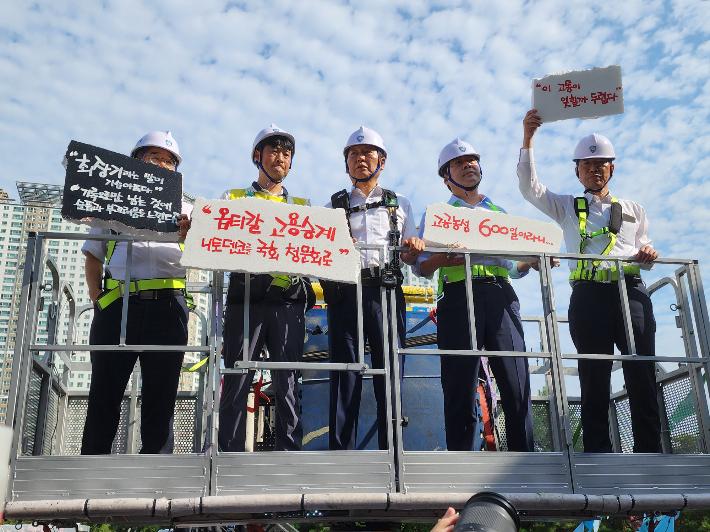더불어민주당 정청래 대표(가운데)가 28일 구미 한국옵티칼하이테크 고공 농성 현장을 찾아 당 차원의 TF 구성을 약속했다. 민주당 경북도당 제공