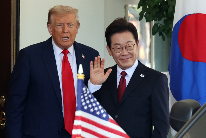 이재명 대통령이 25일(현지시간) 미국 워싱턴DC 백악관에서 영접나온 도널드 트럼프 미국 대통령과 기자들을 바라보며 손을 흔들고 있다. 연합뉴스