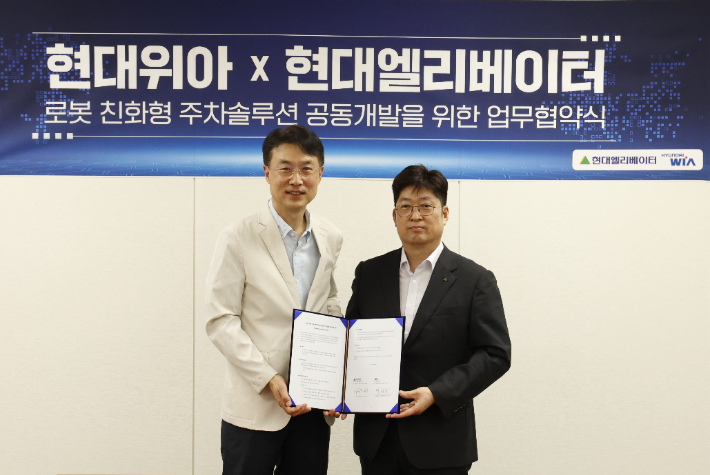 현대위아 모빌리티솔루션사업부 백익진 상무(왼쪽)와 현대엘리베이터 승강기사업본부장 이원해 상무가 28일 경기도 의왕시 현대위아 의왕연구소에서 열린 '로봇 친화형 주차솔루션 공동개발을 위한 업무협약식'에서 협약서에 서명했다. 현대위아 제공