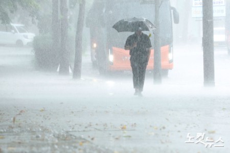 소나기가 내린 29일 오후 서울 종로구의 한 거리에서 우산을 쓴 시민들이 발걸음을 재촉하고 있다.