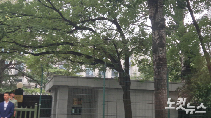 나무 사이로 보이는 주중 북한대사관 앞에서 중국 공안들이 경계를 서고 있다. 임진수 베이징 특파원
