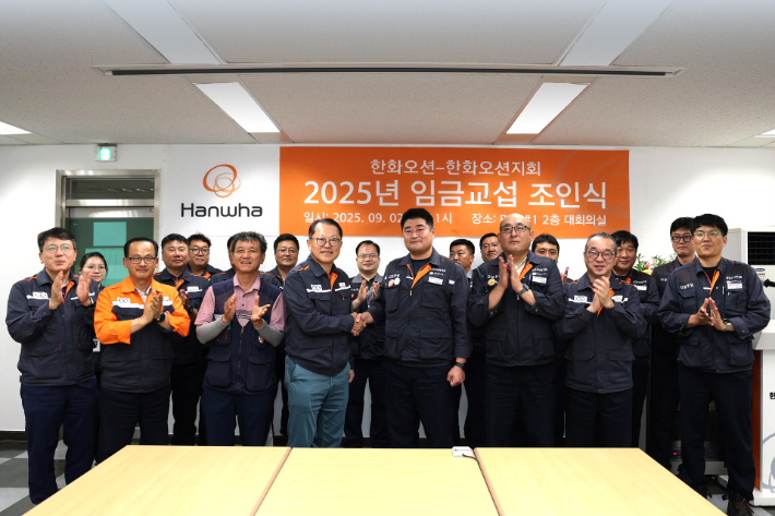 한화오션 김희철 대표이사(앞줄 왼쪽에서 네번째)와 전국금속노조 경남지부 한화오션지회 김유철 지회장(앞줄 왼쪽에서 다섯번째) 등 노사 교섭위원들이 임금 교섭 조인식을 마친 후 기념촬영을 하고 있다. 한화오션 제공