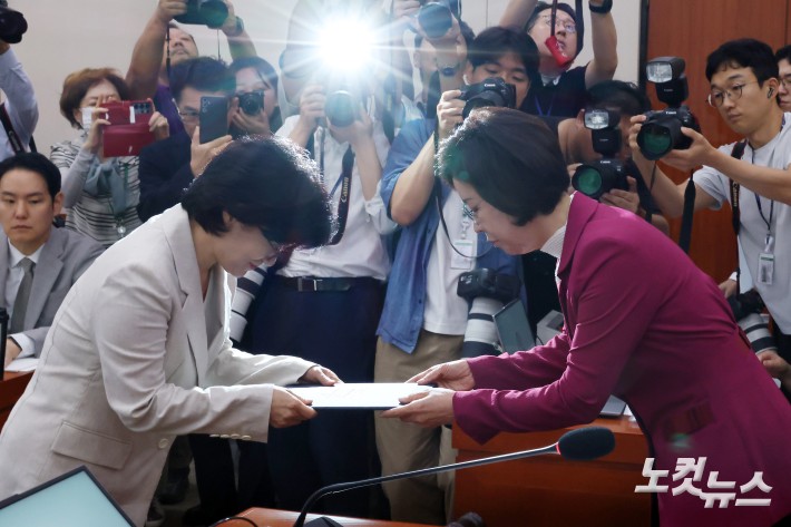 원민경 여성가족부 장관 후보자가 3일 서울 여의도 국회 여성가족위원회에서 열린 인사청문회에서 이인선 위원장에게 선서문을 제출하고 있다.