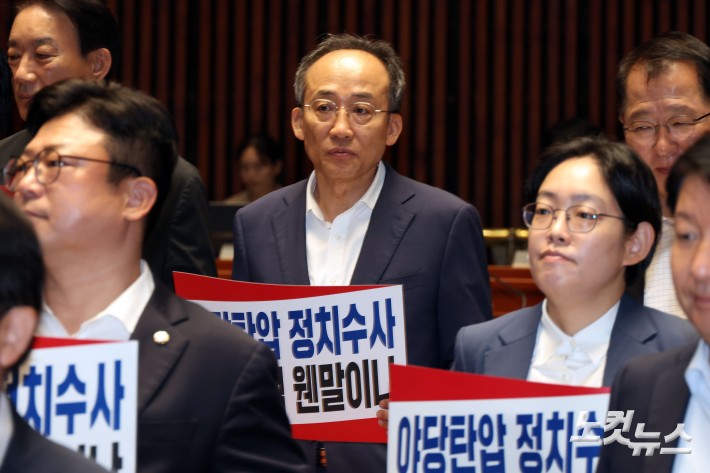 국민의힘 추경호 의원이 3일 서울 여의도 국회에서 열린 당 의원총회에 피켓을 들고 참석하고 있다.