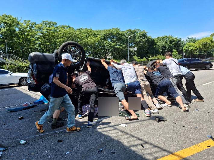 지난달 2일 상록구 부곡동 육교 인근에서 발생한 차량 전복사고 현장에서 시민들이 탑승자를 구하고 있다. 안산시 제공