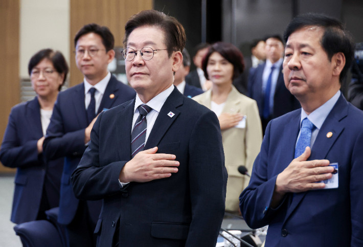 이재명 대통령이 5일 인천 송도 컨벤시아에서 열린 바이오 혁신 토론회에서 국기에 경례하고 있다. 연합뉴스