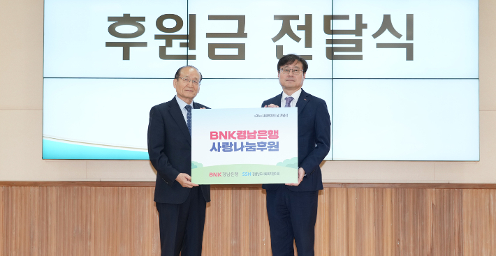 BNK경남은행 최대식 부장(오른쪽)이 제26회 사회복지의 날 기념식에 참석해 경상남도사회복지협의회 박성욱 회장에게 사랑나눔후원 증서를 전달하고 있다. BNK경남은행 제공 