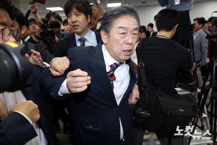 김형석 독립기념관장이 8일 서울 여의도 국회에서 시민단체의 항의를 받으며 기자회견장으로 향하고 있다.