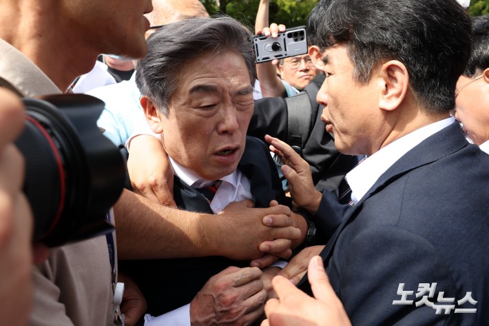 김형석 독립기념관장이 8일 서울 여의도 국회 소통관에서 기자회견을 마친 뒤 시민단체 회원들의 항의를 받으며 나서고 있다.