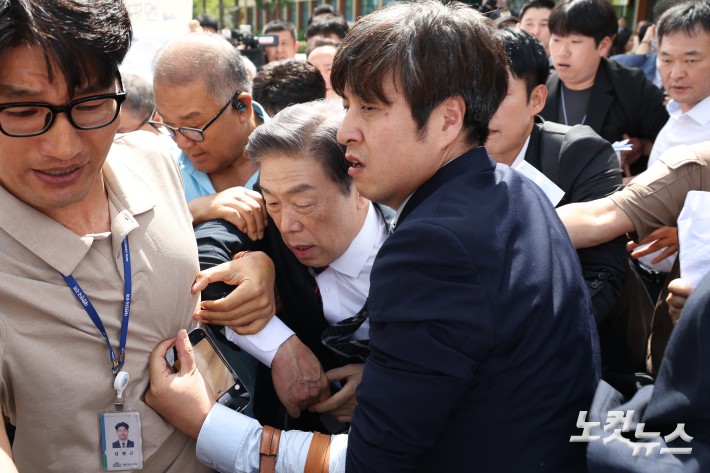 김형석 독립기념관장이 8일 서울 여의도 국회 소통관에서 기자회견을 마친 뒤 시민단체 회원들의 항의를 받으며 나서고 있다.