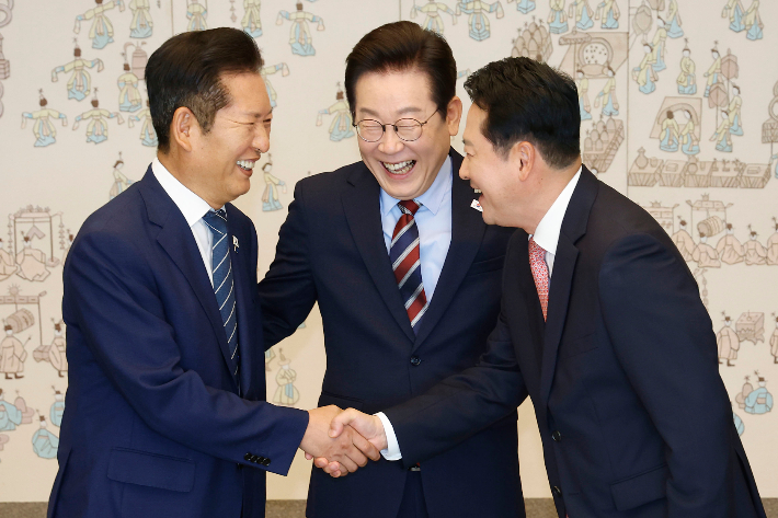 이재명 대통령이 8일 용산 대통령실에서 여야 지도부 오찬 회동에 참석한 더불어민주당 정청래 대표와 국민의힘 장동혁 대표가 악수하는 모습을 보고 있다. 연합뉴스