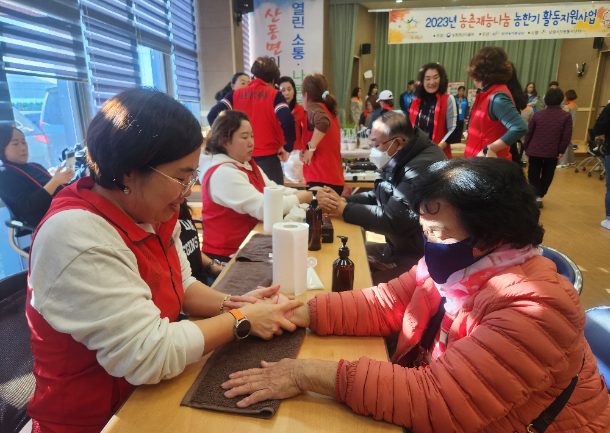 봉사자들이 농촌 마을을 방문해 주민들에게 손마사지를 하고 있다. 농림축산식품부 제공