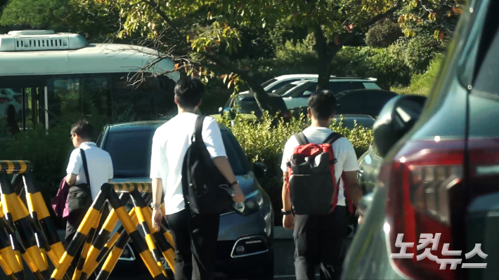 10일 오후 경기도 가평군에 있는 통일교 본부 수련원 외부 정문 앞 주차장에서 통일교 관계자들이 짐을 챙겨 들어가고 있다. 남성경 크리에이터