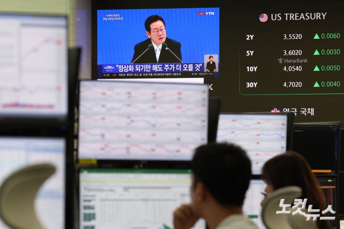 이재명 대통령 취임 100일인 11일 코스피가 전날 기록한 장중 사상 최고치(3,317.77)를 하루 만에 갈아치우며 상승 출발한 가운데 서울 중구 하나은행 딜링룸 현황판에 이재명 대통령 취임 100일 기자회견 방송이 나오고 있다.