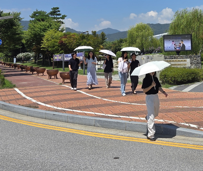 양산을 쓰고 이동 중인 교육청 직원들. 충남교육청 제공