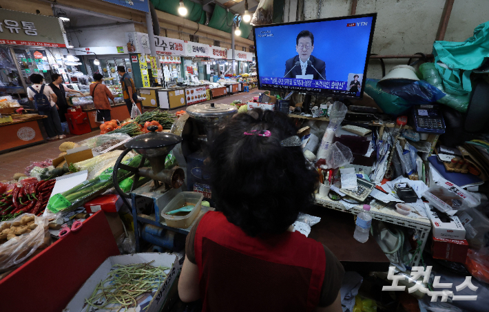 지난 11일 서울 서대문구 인왕시장에서 상인들이 '이재명 대통령 취임100일 기자회견'을 시청하고 있는 모습. 황진환 기자