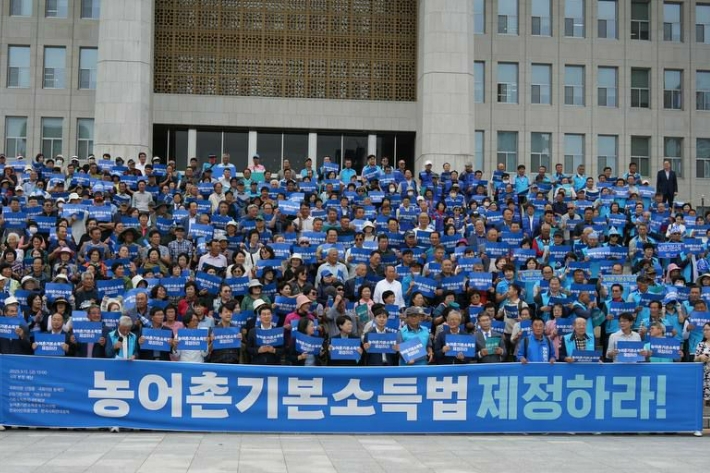 12일 오후 1시, 국회 본청 앞에서 신정훈 국회의원(더불어민주당, 국회 행정안전위원장)과 용혜인 의원(기본소득당 대표)을 비롯해 여야 국회의원, 농어민·어민·소상공인·청년 귀농인 등 500여 명이 참여해 「농어촌기본소득 입법 촉구 500인 기자회견」을 개최한 후 기념사진을 찍고 있다. 신 의원실 제공