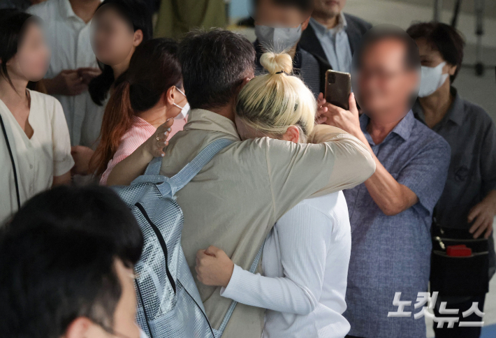 이민 단속으로 체포됐던 미국 현대차-LG엔솔 배터리공장 건설 현장 직원이 12일 인천국제공항 제2터미널로 귀국한 뒤 장기주차장에서 대기 중이던 가족과 만나 포옹하고 있다. 인천공항=황진환 기자