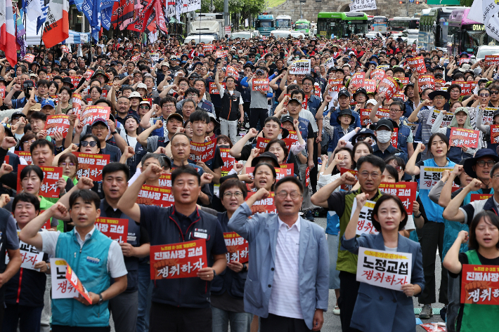 전국민주노동조합총연맹(민주노총) 조합원들이 13일 서울 중구 시청역 인근에서 결의대회를 열고 노동자 노동기본권과 노정교섭 쟁취 등을 촉구하며 구호를 외치고 있다. 연합뉴스