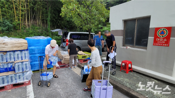 강릉시가 300세대 이상 아파트에 대한 2차 생수 배부를 15일부터 시작한 가운데 강릉의 한 아파트 주차자에서 입주민들이 생수를 받아가고 있다. 전영래 기자