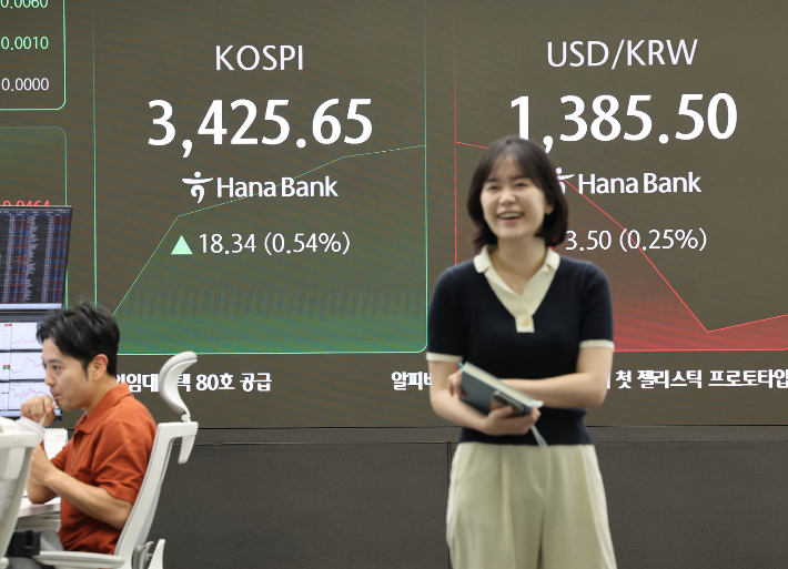 코스피가 상승 출발한 16일 서울 중구 하나은행 딜링룸에서 한 딜러가 활짝 웃고 있다. 연합뉴스