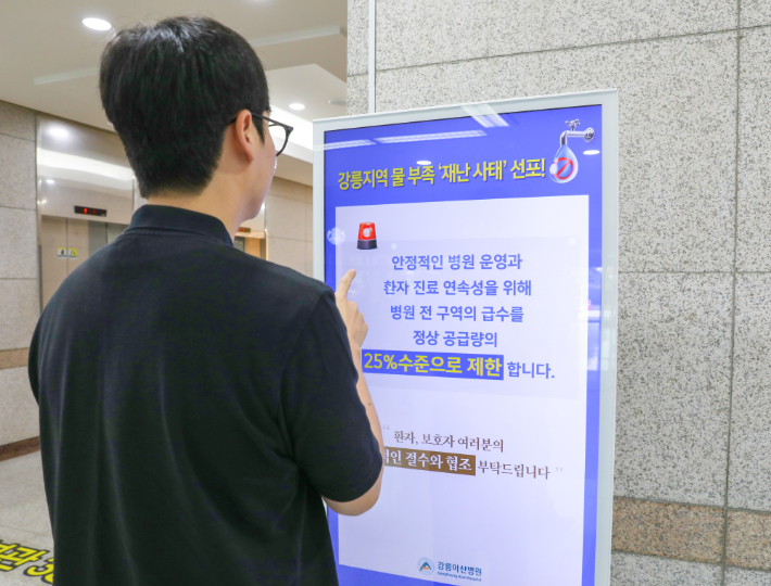 내원객이 병원 내에 설치된 절수 운동 포스터를 바라보고 있다. 강릉아산병원 제공