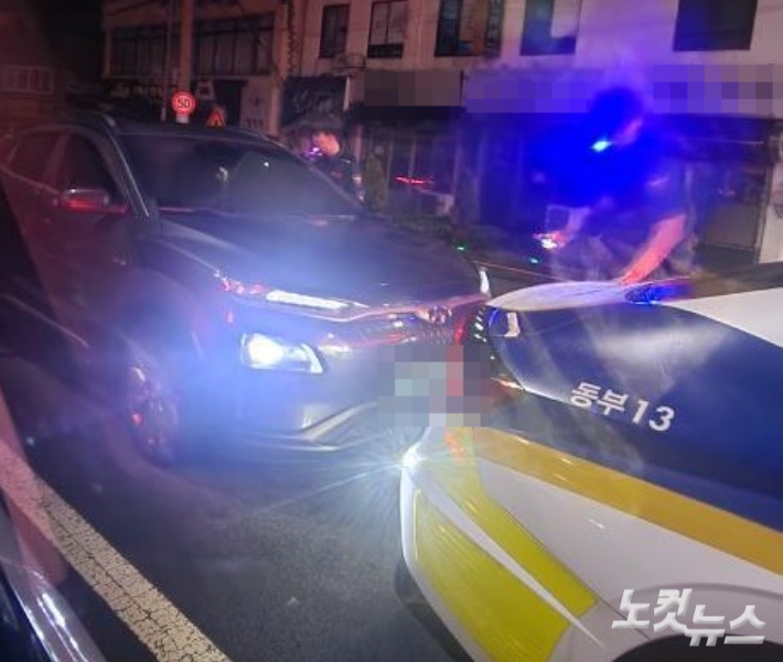 지난 15일 새벽 동문시장 인근 도로 한복판에서 만취 상태로 잠에 든 남성을 경찰이 깨우고 있다. 독자 제공