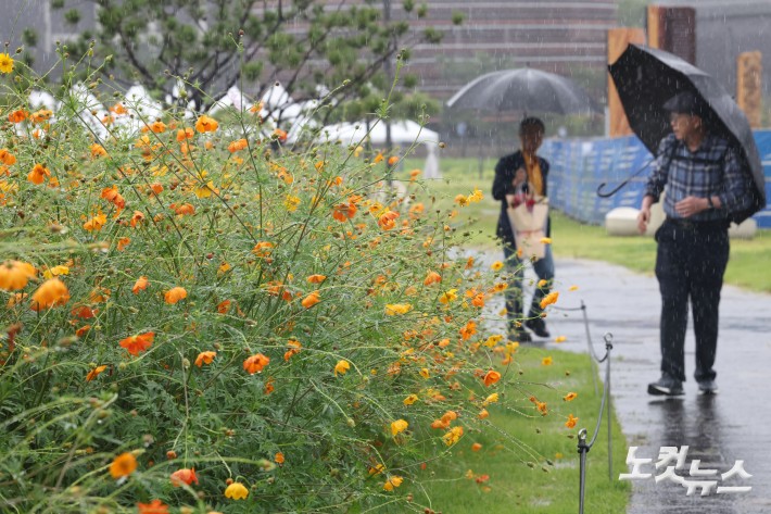 전국 곳곳에 거센 가을비가 내린 17일 서울 종로구 열린송현 녹지광장에서 우산을 쓴 시민들이 발걸음을 재촉하고 있다.