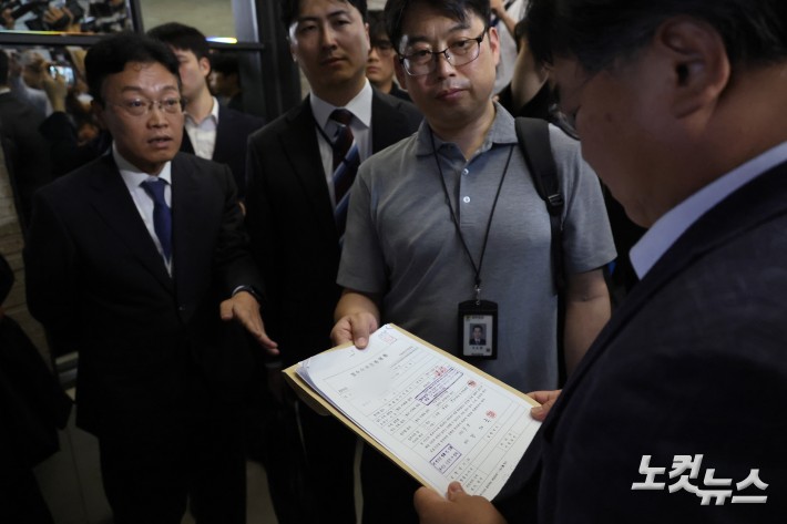 김건희 특검팀(민중기 특별검사)이 18일 서울 여의도 국민의힘 중앙당사에서 국민의힘 변호사에게 압수수색 영장을 제시하고 있다.