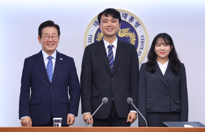 이재명 대통령이 18일 서울 용산 대통령실에서 이주형(가운데), 최지원(오른쪽) 청년담당관에게 임명장 수여 후 기념촬영을 하고 있다. 연합뉴스