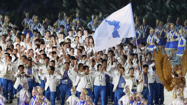 지난 2018년 8월 18일 오후(현지시간) 인도네시아 자카르타 겔로라 붕 카르노(GBK) 스타디움에서 열린 2018 자카르타ㆍ팔렘방 아시안게임 개막식에서 남북 선수단이 한반도기를 든 남측 여자농구 남북단일팀 주장 임영희, 북측 남자 축구 주경철을 선두로 공동 입장하고 있다. 연합뉴스