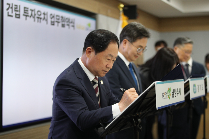 지난 6월 13일 경기도청에서 열린 '카카오 AI 기반 디지털허브 건립 투자유치 업무협약식'에서 주광덕 시장이 서명을 하고 있다. 남양주시 제공