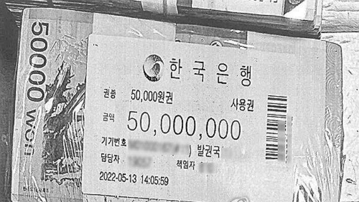 지난해 무속인 '건진법사' 전성배씨의 자택에서 나온 한국은행이 적힌 비닐로 포장된 돈뭉치. 연합뉴스