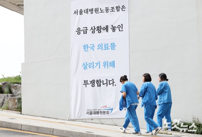 서울대병원노조가 오는 24일부터 임금체계 개선을 요구하며 무기한 전면 파업을 예고한 가운데 22일 서울 종로구 서울대학교병원 건물에 관련 현수막이 부착돼 있다.