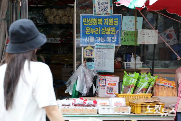 2차 민생회복 소비쿠폰 지급일인 22일 서울 시내 한 시장 상점에 사용처 안내문이 붙어 있다. 이날부터 전 국민의 약 90%를 대상으로 1인당 10만원을 지급하며, 신청 첫주에는 시스템 과부하 등을 방지하기 위해 출생연도 끝자리에 따른 요일제가 적용된다. 신청은 10월 31일 오후 6시까지 가능하다.