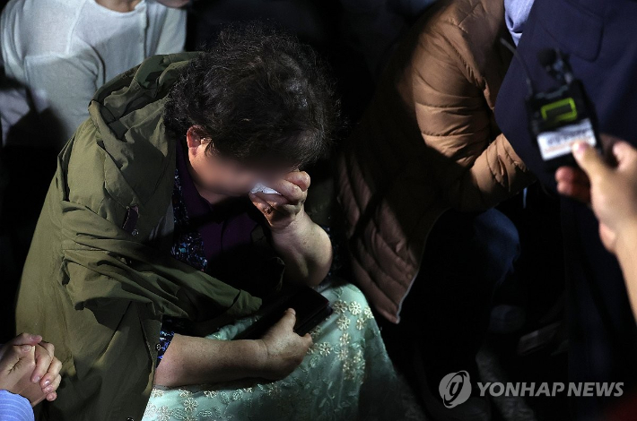 윤석열 정권과 통일교 간 '정교유착 국정농단' 의혹을 받는 한학자 통일교 총재가 23일 새벽 구속되자 경기도 의왕 서울구치소 앞에서 이를 지켜보던 신도들이 슬픔에 잠겨 있다. 연합뉴스