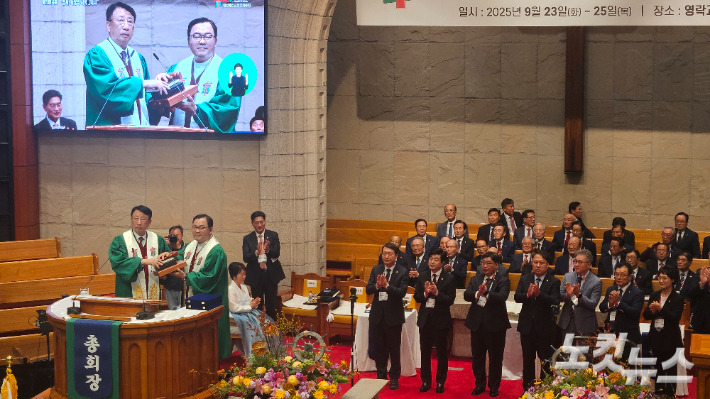대한예수교장로회 통합총회가 23일 서울 중구 영락교회에서 제110회 총회를 시작하고, 정훈 목사부총회장을 신임 총회장으로 선출했다. 정훈 신임 총회장이 김영걸 109회기 총회장으로부터 의사봉과 성경책을 넘겨 받고 있다. 송주열 기자.