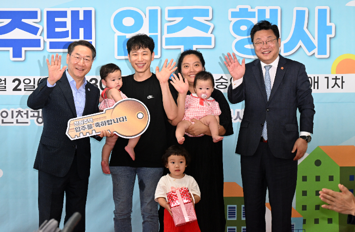 인천 미추홀구 숭의동 한 빌라에서 열린 '천원주택' 입주 행사에서 입주 가족들이 유정복 인천시장(왼쪽 첫 번째), 주형환 저출산고령사회 위원회 부위원장(오른쪽 첫 번째)과 함께 기념사진을 찍는 모습. 인천시 제공