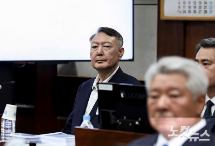 윤석열 전 대통령이 26일 서울 서초구 서울중앙지방법원에서 열린 '특수공무 집행 방해, 직권남용 권리행사 방해 혐의' 첫 재판에 출석해 있다. 사진공동취재단