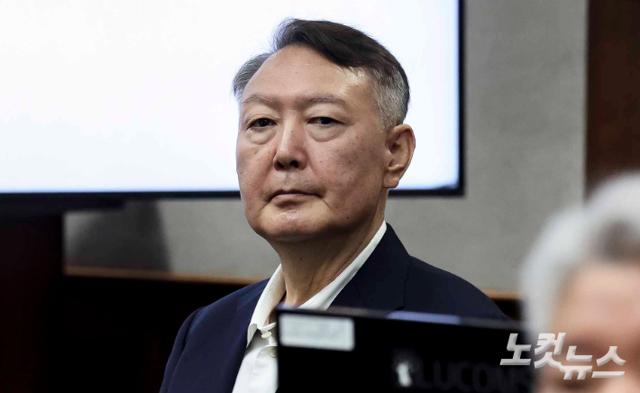 윤석열 전 대통령이 26일 서울 서초구 서울중앙지방법원에서 열린 '특수공무 집행 방해, 직권남용 권리행사 방해 혐의' 첫 재판에 출석해 있다. 사진공동취재단