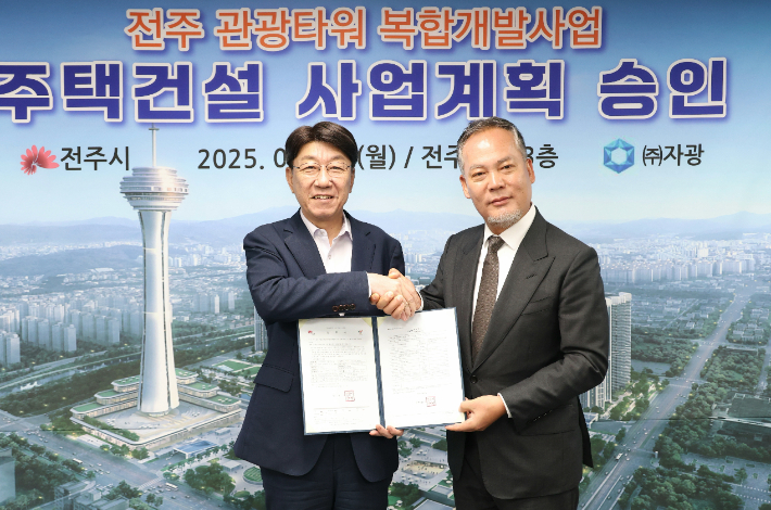우범기 전주시장(왼쪽)과 ㈜자광 전은수 대표이사가 29일 전주 관광타워 복합개발사업 사업계획 승인서를 들고 악수를 나누고 있다. 전주시 제공