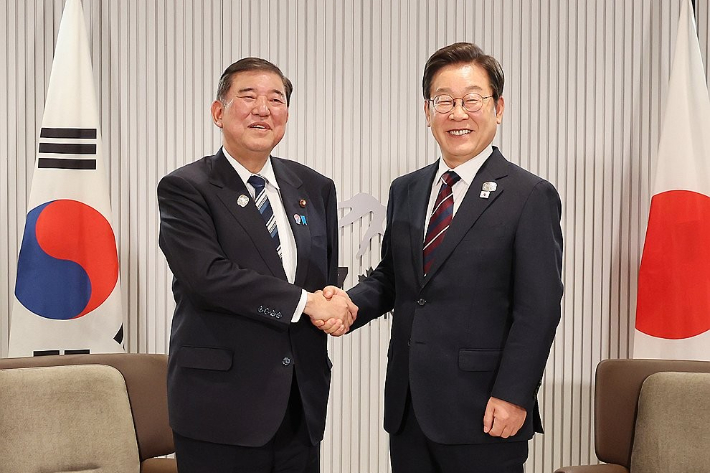 이재명 대통령이 지난 6월 17일(현지시간) 캐나다 앨버타주 캐내내스키스 주요 7개국(G7) 정상회의장에서 열린 한일 정상회담에서 이시바 시게루 일본 총리와 악수하며 기념촬영을 하고 있다. 연합뉴스