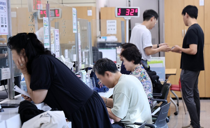 국가정보자원관리원(국정자원) 대전 본원 화재로 전산망 마비 사태가 나흘째 이어지는 29일 서울의 한 주민센터에서 시민들이 업무를 보고 있다. 연합뉴스