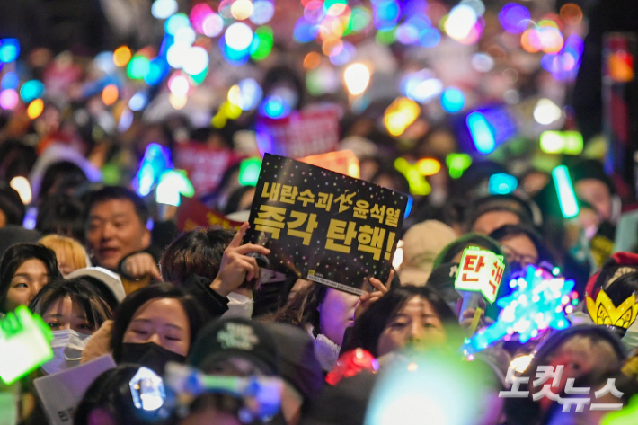 서울 여의도 국회 앞에서 열린 윤석열 대통령 탄핵 촉구 집회에서 많은 시민들이 K팝 '다시 만난 세계' 등을 열창하며 야광봉을 흔들고 있다. 