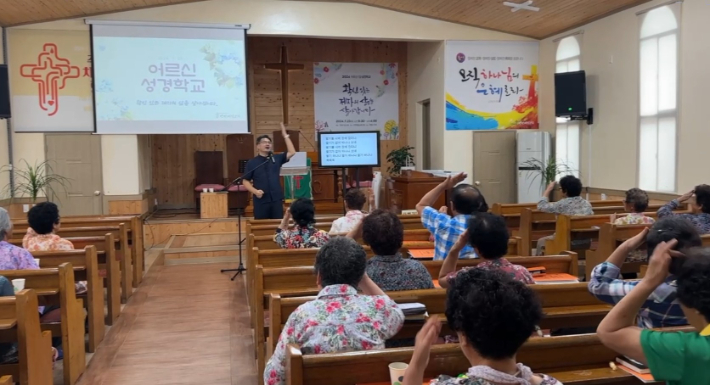 전남 구례 간전제일교회 곽명수 담임목사가 '어르신 성경학교'에서 성도들과 함께 몸으로 하는 활동을 하고 있다. 곽명수 목사 제공